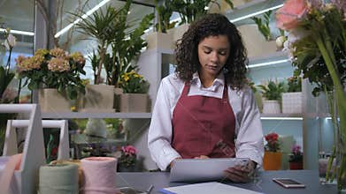 Florist taking orders using tablet in flower shop