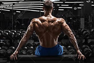 Rear view muscular man showing back muscles at the gym. Strong male naked torso, workout