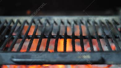 Grill close up against the background of fire and smoke of burning coals