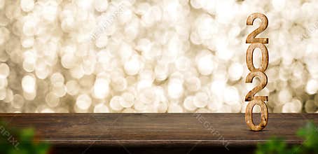 Happy New Year 2020 wood with sparkling star on brown wood table with gold bokeh background,Holiday festive celebration concept.