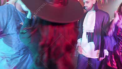 Group of young friends at a halloween party dancing and having fun