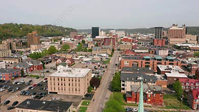Aerial elevating up over a church clocktower and Charleston West Virginia