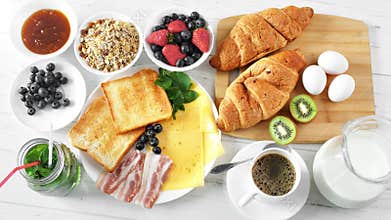 Top view female hand putting bakery croissant on serving table ready for breakfast POV shot