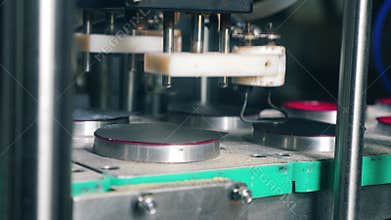 Metal equipment working with plastic containers at a food factory.