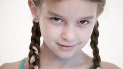 Close-up open look of a Caucasian girl with a pigtails opening and closing her eyes. Angry and blind in the camera