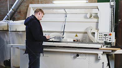 Engineer setting up automatic edge bander machine