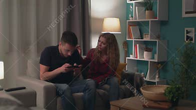 Panning of man play in game on smartphone and ignores his girlfriend
