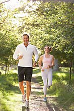Middle Aged Couple Jogging In Park
