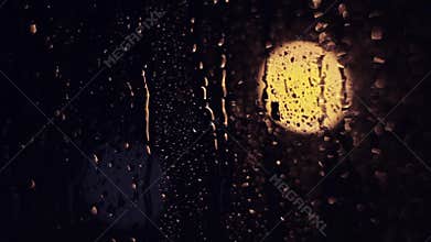 The lights of the night city. Misted glass. Liquid raindrops on the window. Sadness and sad mood background.