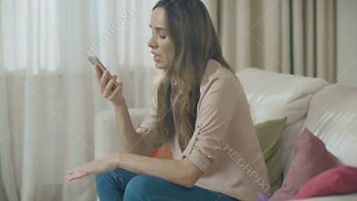 Angry woman talking phone at home. Portrait of upset person call mobile phone