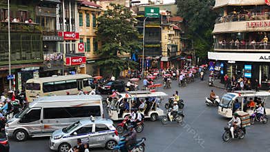 View of busy traffic in an intersection with many motorbikes and vehicles in Hanoi, capital of Vietnam.