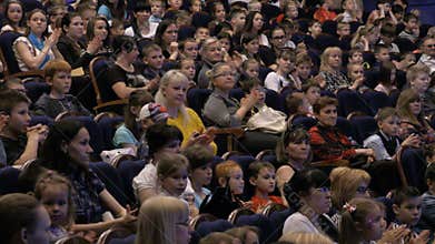 The audience applauded for a performance or presentation in the theater. Children and adults alike. Theatre of the young spectator