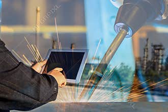 Businessman is used tablet control automate wireless Robot welding.