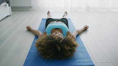 Woman lying on mat relaxing and breathing