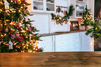 Christmas holiday background with empty rustic table and the bokeh of the living room with the Christmas tree on the second plan