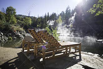 Wooden lounge chairs near a hot spring