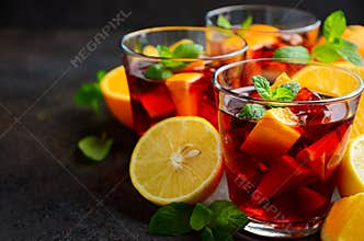 Spanish sangria cocktail and ingredients on dark concrete or stone background.