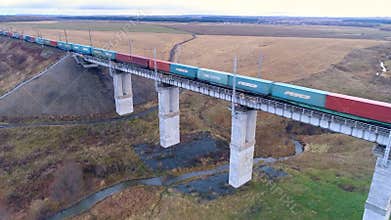 A train transports shipping containers over a bridge.