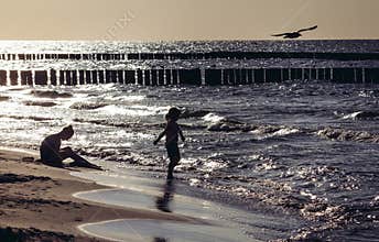 Mother and child on beach at baltic sea near Sarbinowo in Poland