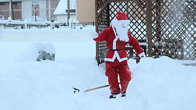 Santa claus taking with shovel snow away to make the way free and fall down