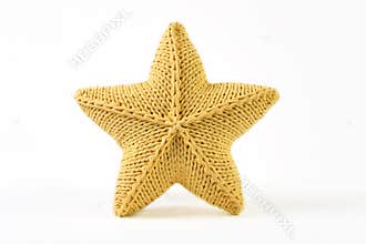 Yellow knitted five-pointed star shaped pillow on white background.