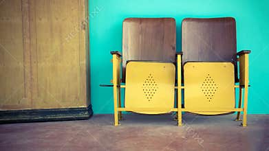 Close up of old wooden folding cinema chair or folding seat in front of Asian theater.