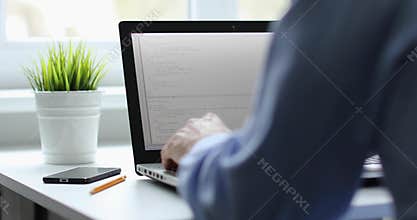 Programmer working on laptop in office writing programming code