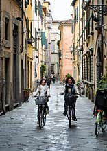 Two young women cycling in Lucca, Italy