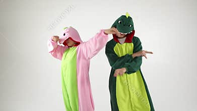 Dinosaur costumes absurd dancing couple. Funny party mood. White background video footage