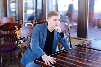 CEO with smartwatch waiting order in cafe and thinking about new