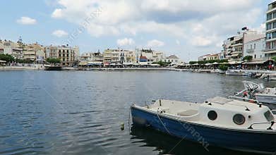 Cityscape of Agios Nikolaos Crete Greece. Boats at volcano lake voulismeni and harbor. Traditional houses around the caldera wit
