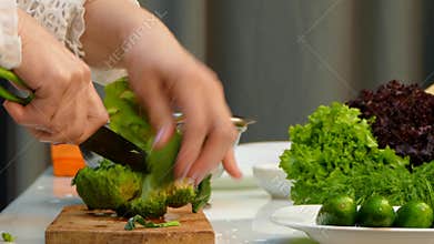 Chef Cutting Fresh Broccoli On Carving Board