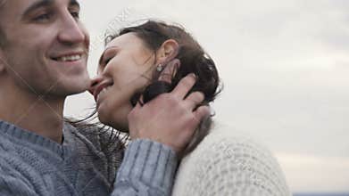 Lovely man kisses his girl on the rock. 4K