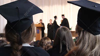 Many people at ceremony to celebrate graduation. Dean shaking student's hand