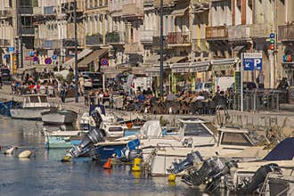 One sunny day along the waterfront in Sete France people enjoy lunch