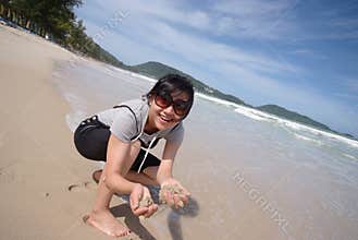Woman holding sand on beach