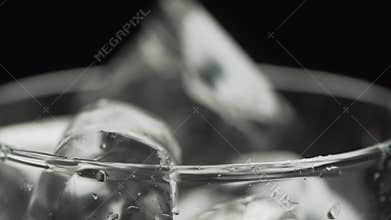 Slow Motion : Ice cubes pouring into a glass and bokeh background