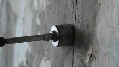 Drilling of concrete with a round construction crown. worker drills a wall with a perforator. Slow motion video