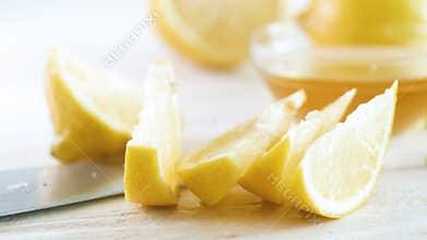 4k panning video of freshly cut lemons, knife and ingredients for lemonade on white wooden desk