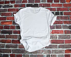 Flat lay mockup of white tee shirt on brick background