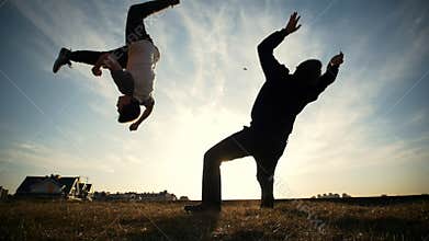 Two young men outdoors fighting on the sunset
