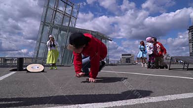 UKRAINE, DNIPRO - APRIL 24, 2018: Children dance hip-hop on a skyscraper floor against a cloud background