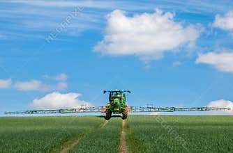 John Deere R4040i sprayer spraying in wheat field