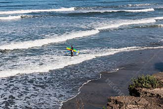 Two Male Surfers Carrying Surfboards in the Water at San Elijo State Beach