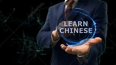 Businessman shows concept hologram Learn Chinese on his hand
