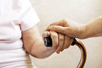 Close up of mature womans & nurse hands. Health care giving, nursing home. Parental love of grandmother. Old age related diseases.