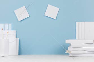 School template - white books, stationery, blank stickers on white desk and soft blue background.
