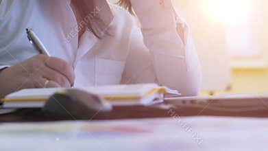 Inspired woman writing ideas in diary, freelance journalist working on article