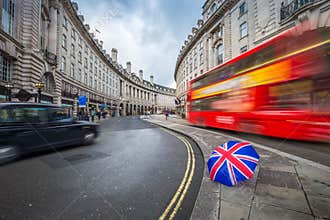 London, England - Iconic red double-decker bus and black taxi on the move on Regent Street