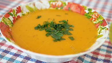 Cooked and decorated with greens pumpkin cream soup in a plate. Healthy food